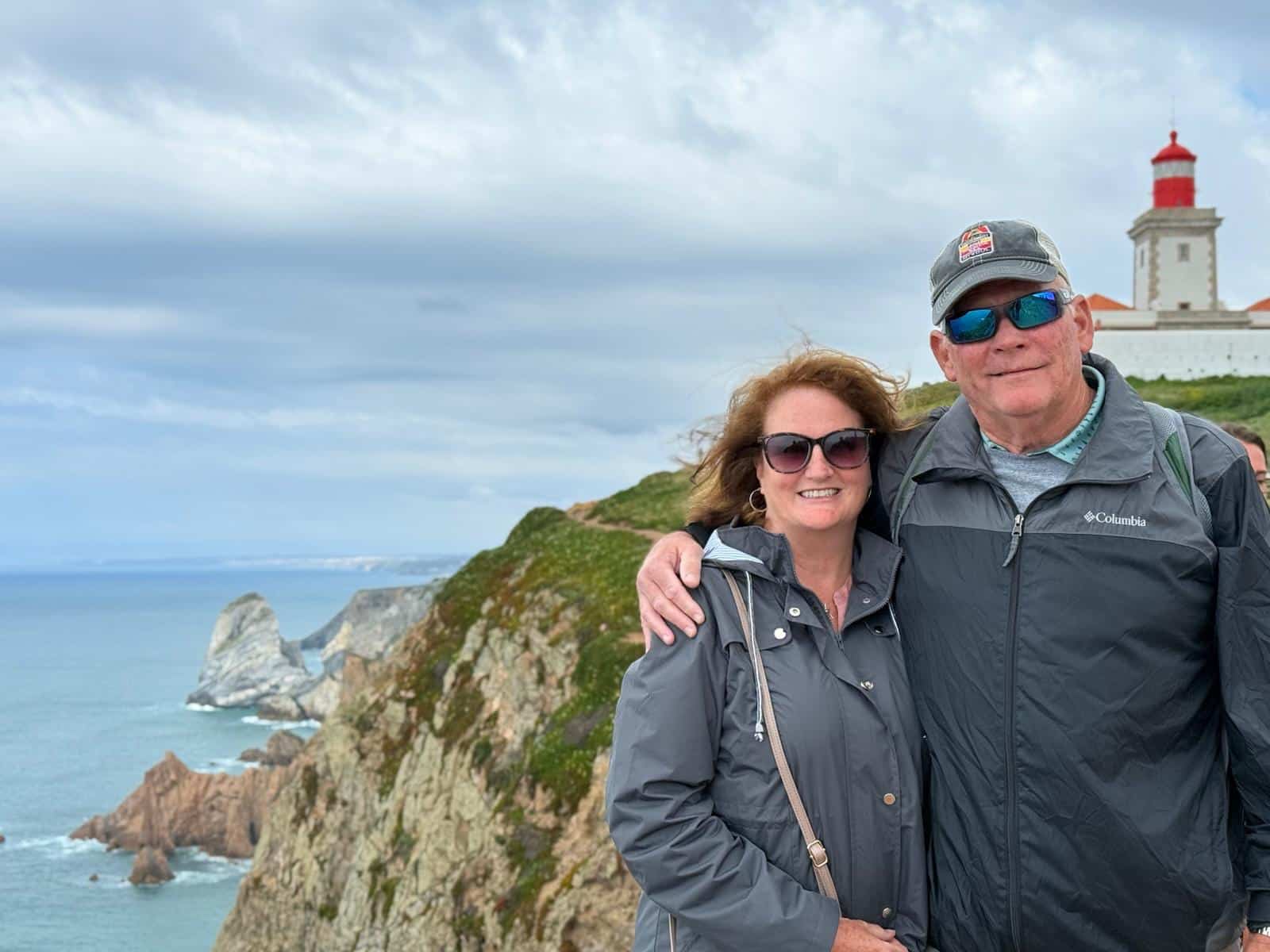 Guests at Cabo da Roca with the lighthouse and Atlantic coast behind them