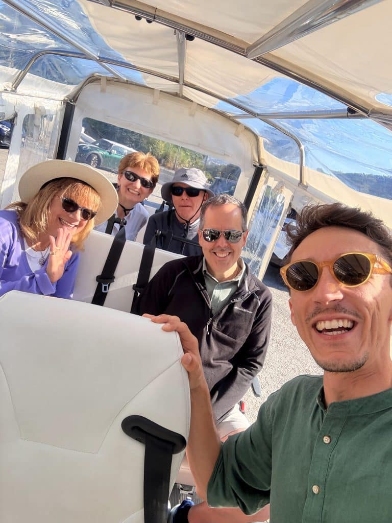 Daniel and four guests smiling together inside a tuk tuk.