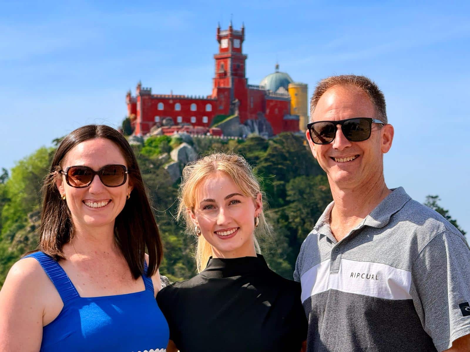 Three travelers together with Pena Palace in the background.