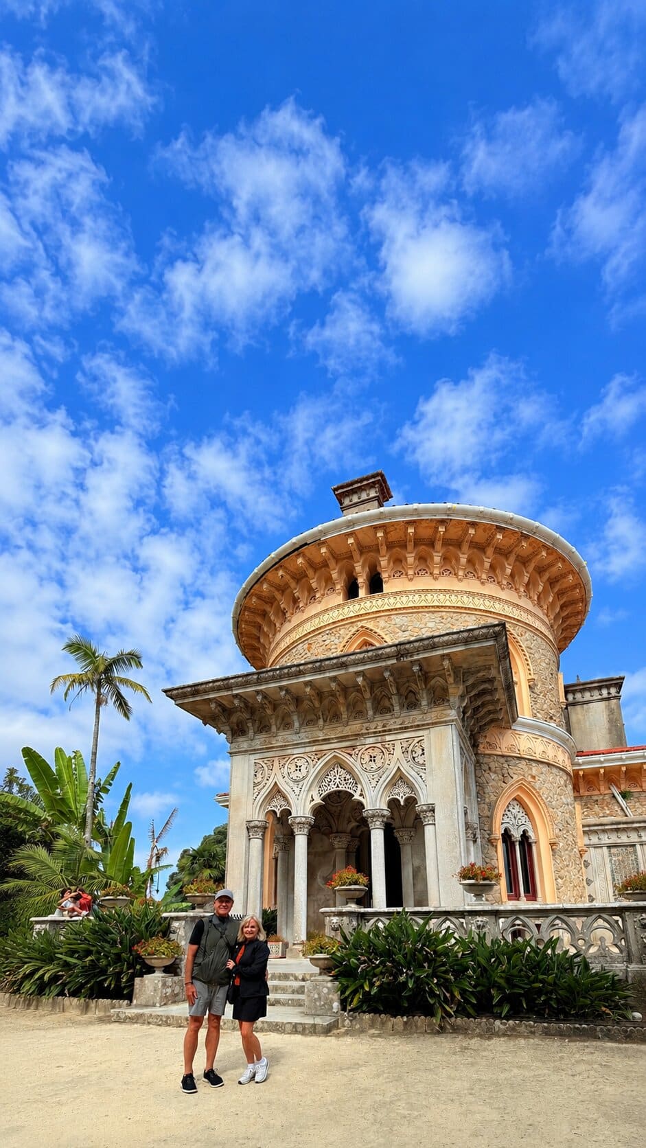 A couple standing below the carved entrance and domed tower of Monserrate Palace