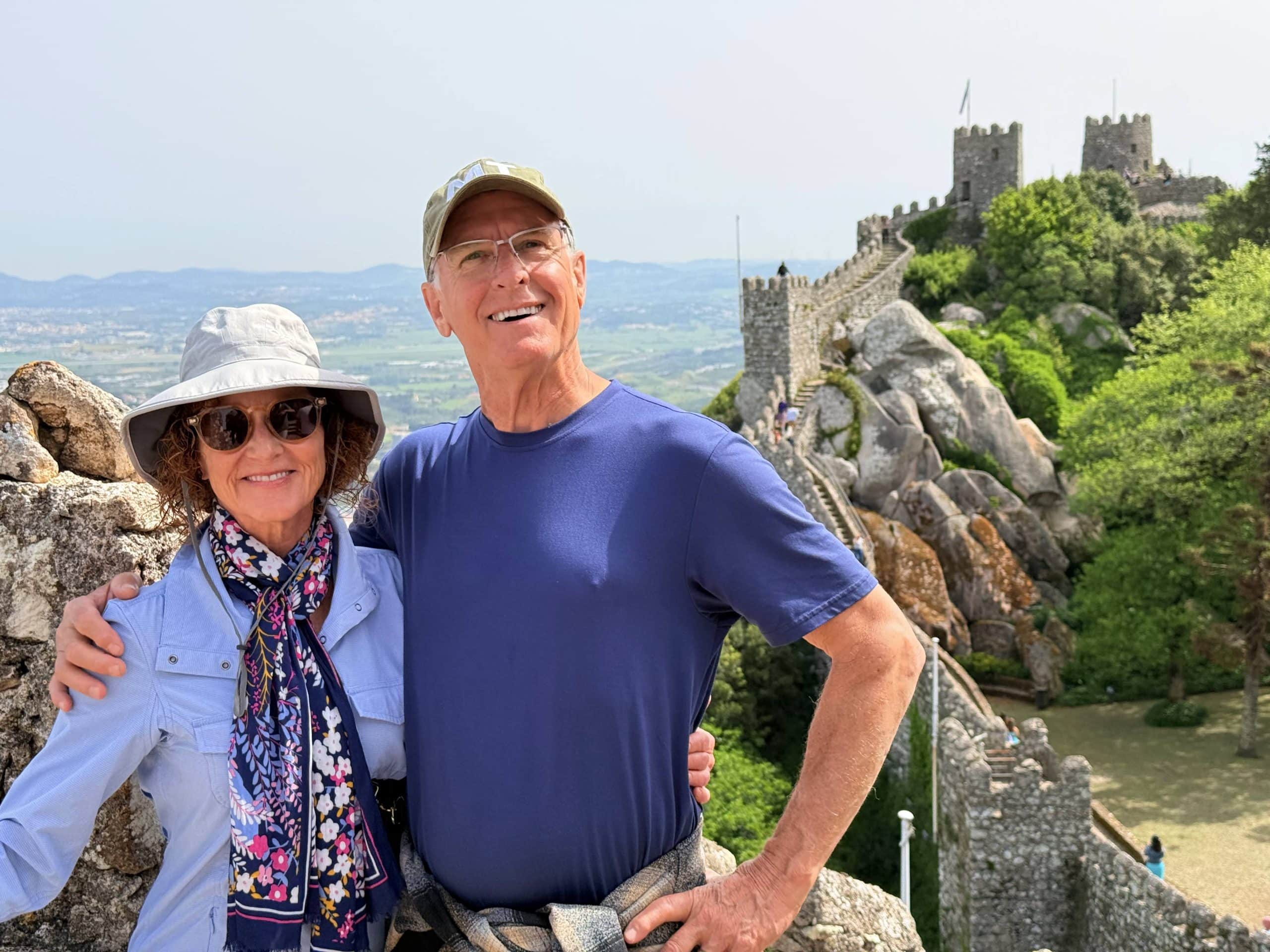 A couple enjoying the views beside the walls of the Moorish Castle in Sintra.