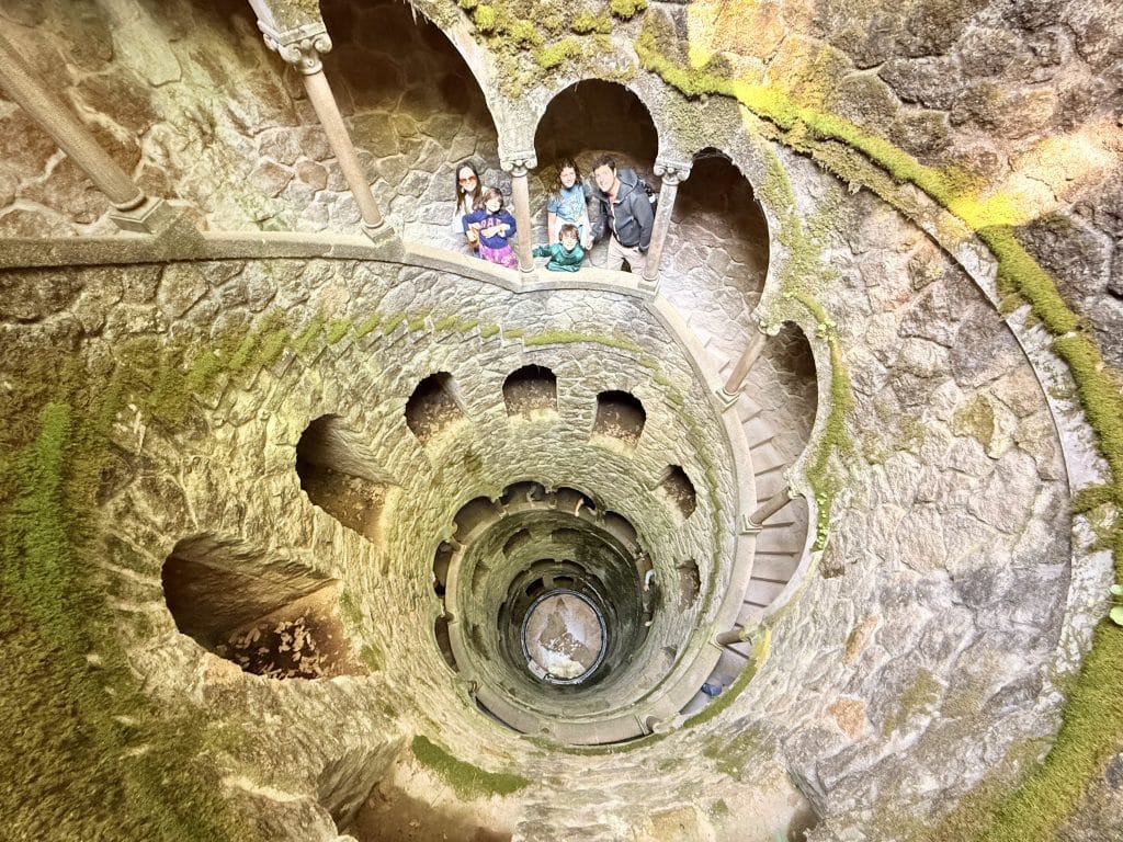 Visitors inside the Initiation Well at Quinta da Regaleira in Sintra, Portugal.