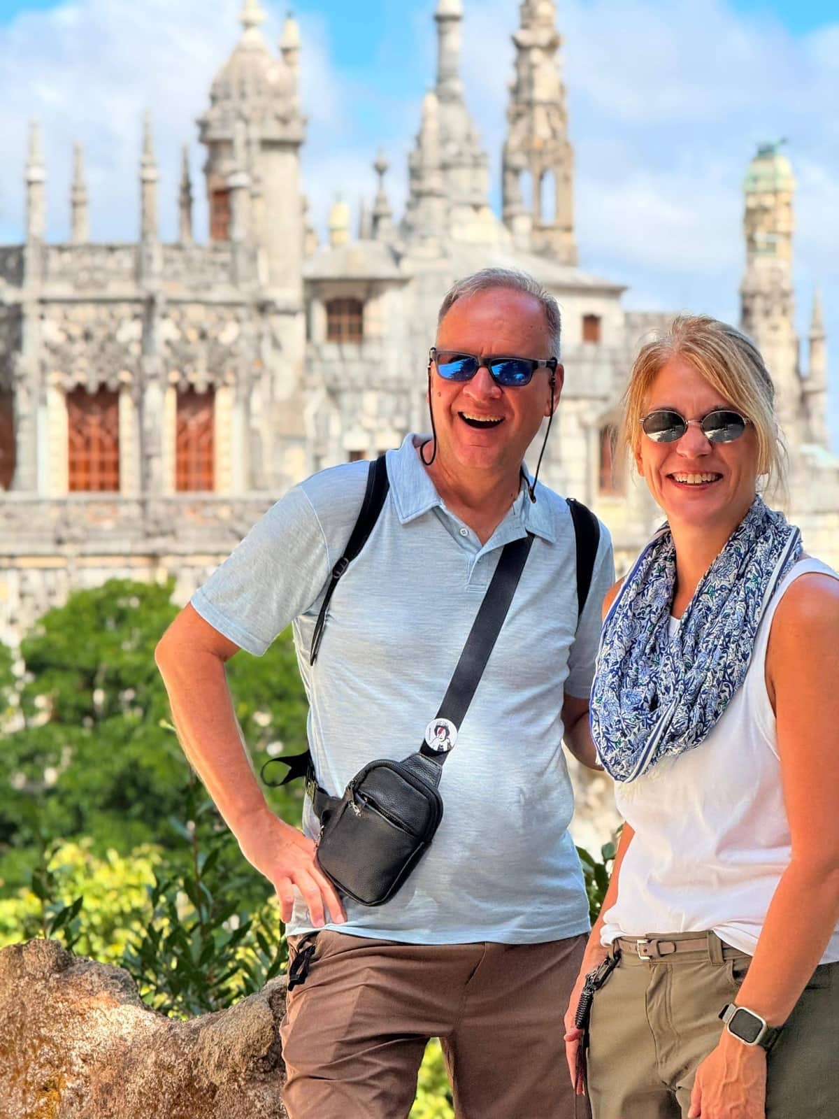 A couple smiling together in front of Quinta da Regaleira Palace in Sintra