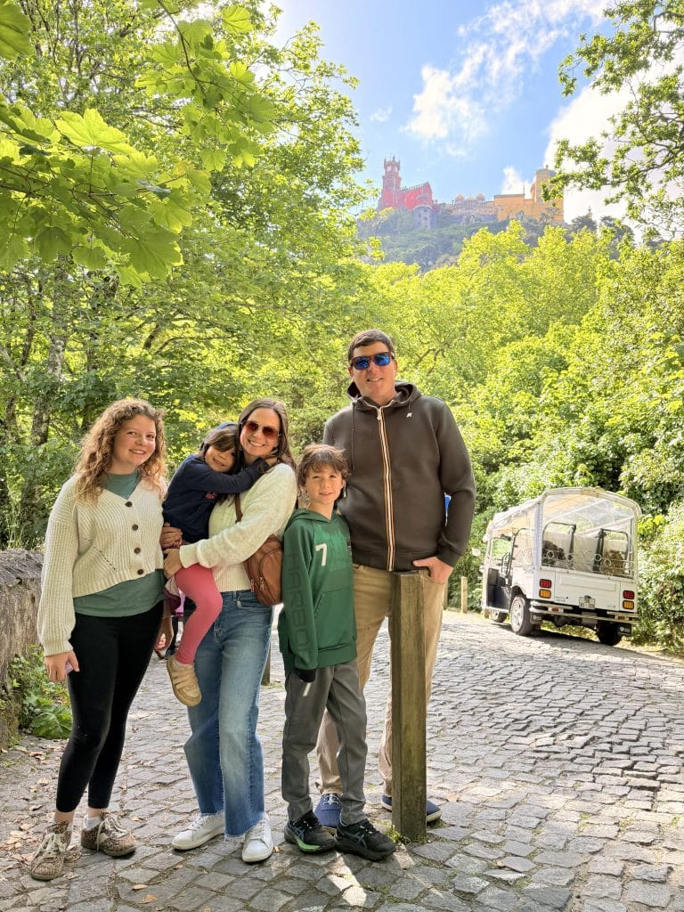 A family standing on a cobbled path in the wooded hills of Sintra