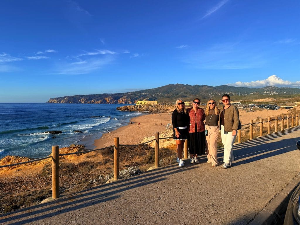 Five visitors on a wooden boardwalk overlooking a rocky coastline