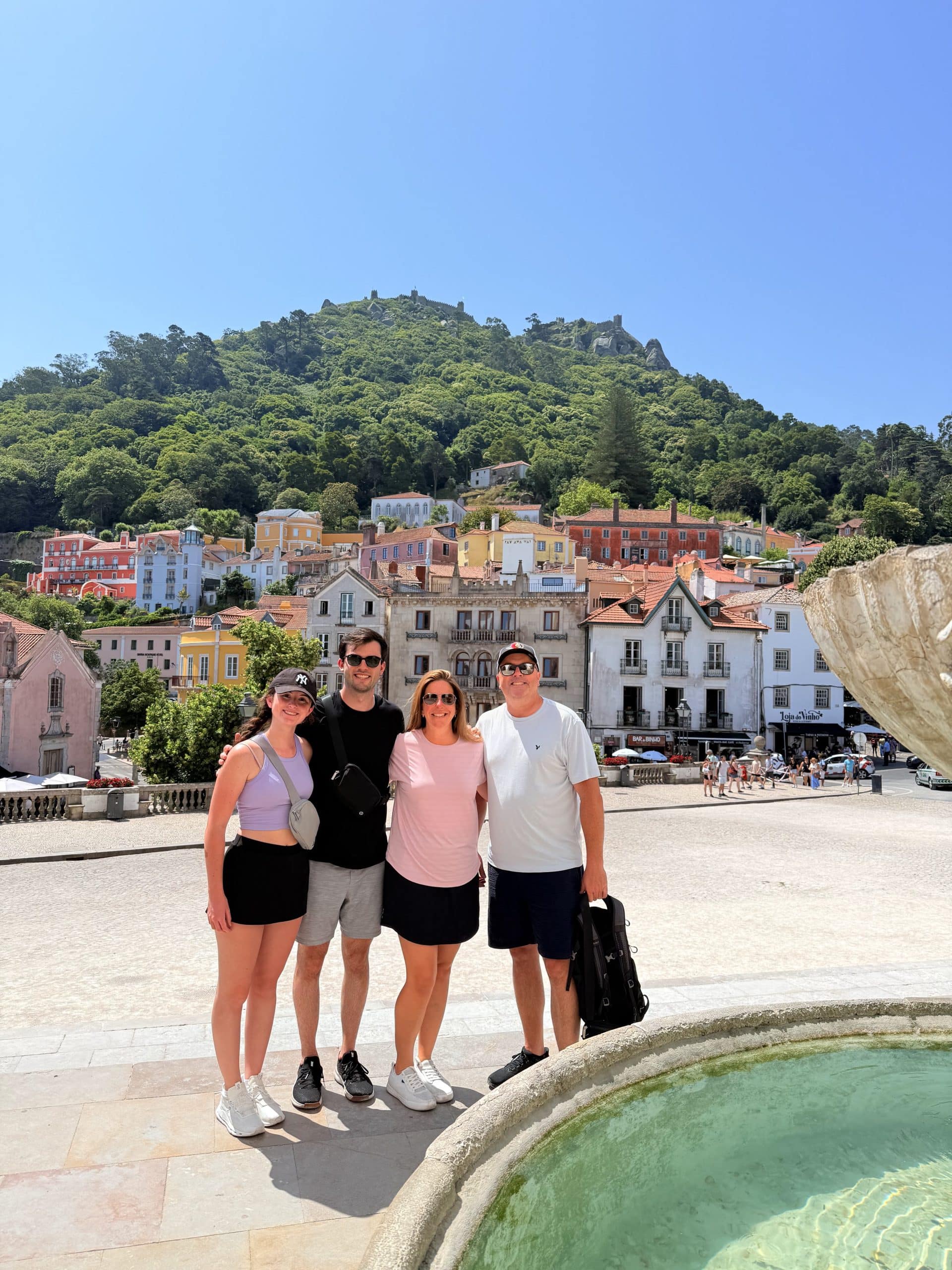 Visitantes em Sintra cidade com edifícios pastel e as colinas arborizadas atrás deles