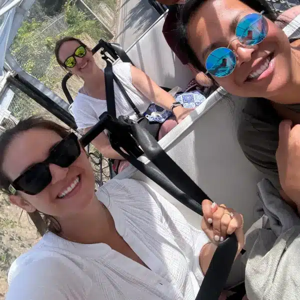 Happy travelers enjoying a comfortable private tuk tuk ride through the scenic roads of Sintra, Portugal, during a guided tour.