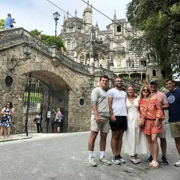 Tourists in front of Quinta da Regaleira entrance in Sintra, Portugal โ group photo with the famous neo-Gothic palace in the background