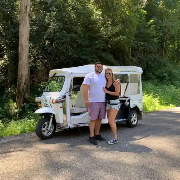 Couple enjoying a private Sintra tuk tuk tour through a scenic forest road with Yes, You Deserve โ a romantic and unforgettable experience exploring Portugalโs natural beauty and hidden gems.